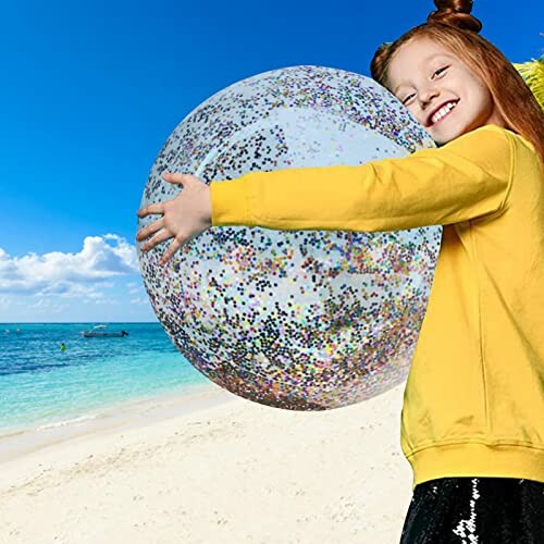 Kind met glitterbal op het strand.