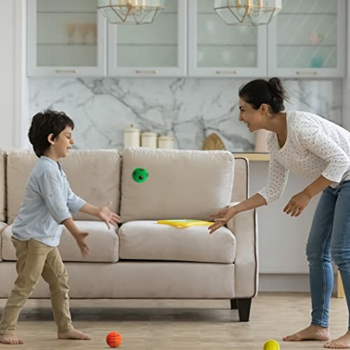 Moeder en kind spelen met ballen in de woonkamer.